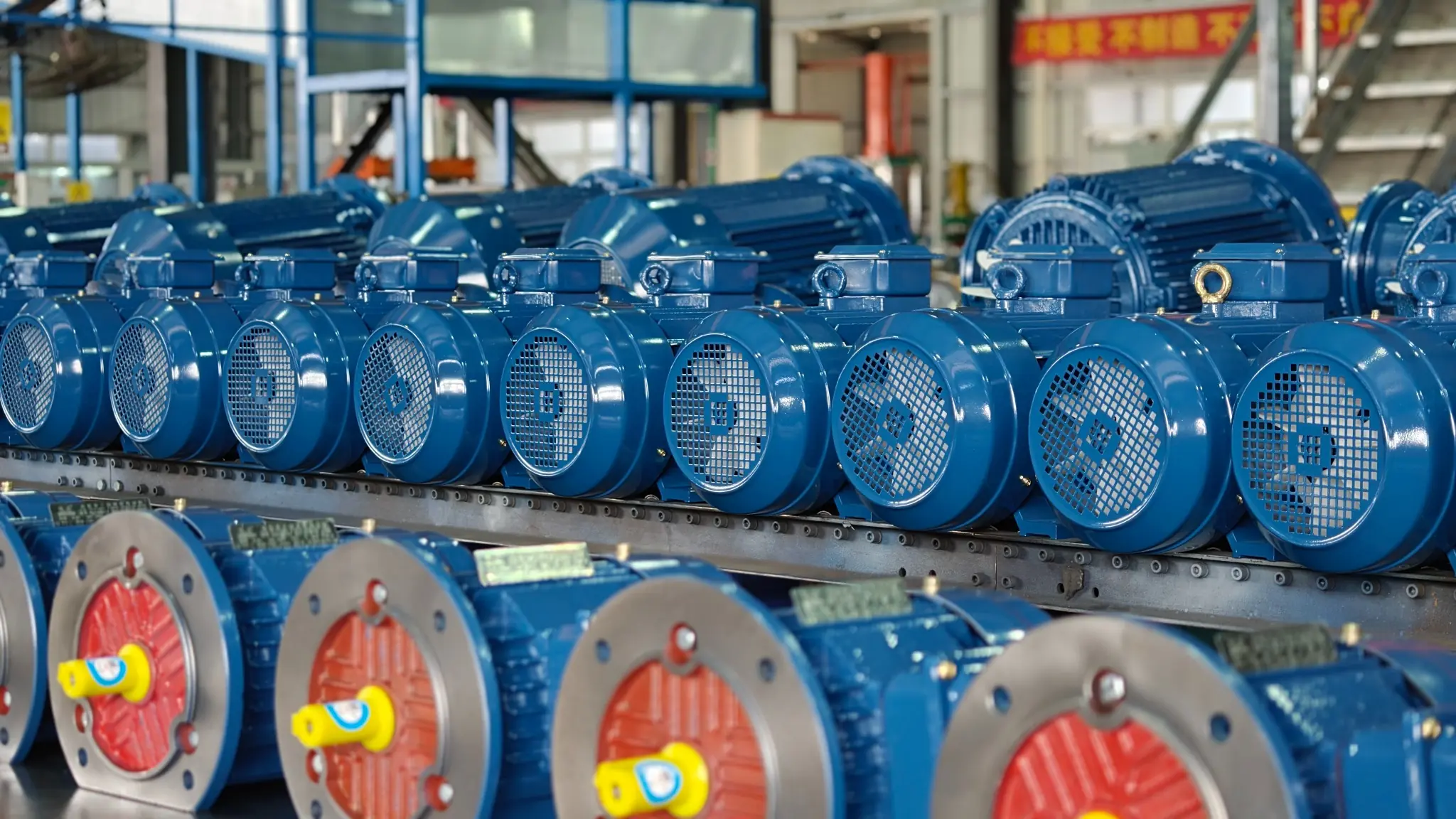 Blue industrial electric motors arranged on a production line inside a motor manufacturing workshop